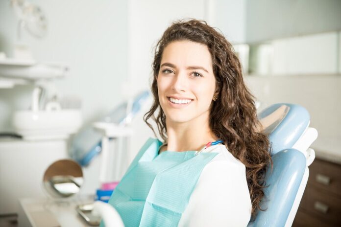 portret-usmiechnietej-mlodej-kobiety-siedzacej-na-krzesle-w-klinice-dentystycznej_662251-2583 Rola szczoteczek sonicznych w codziennej pielęgnacji jamy ustnej